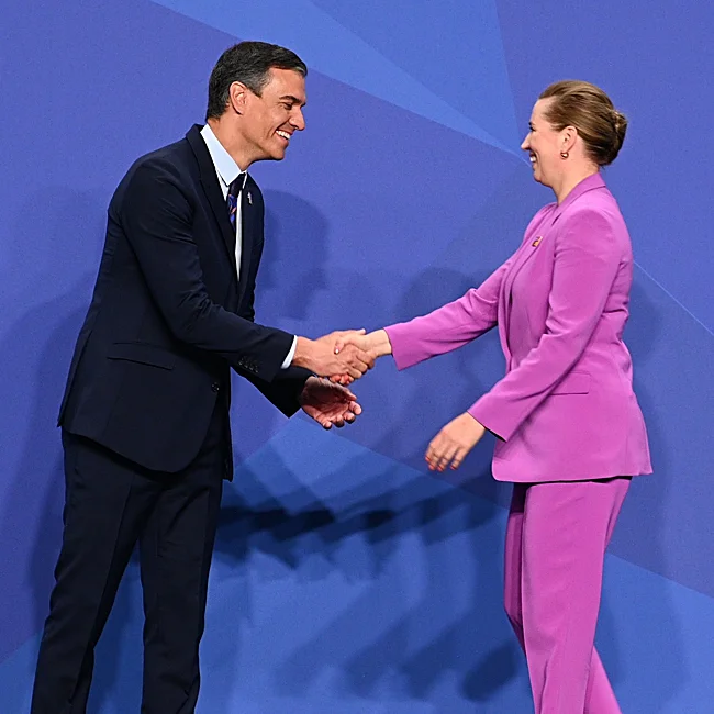 Mette Frederiksen sveikina Pedro Sánchez per NATO susitikimą.